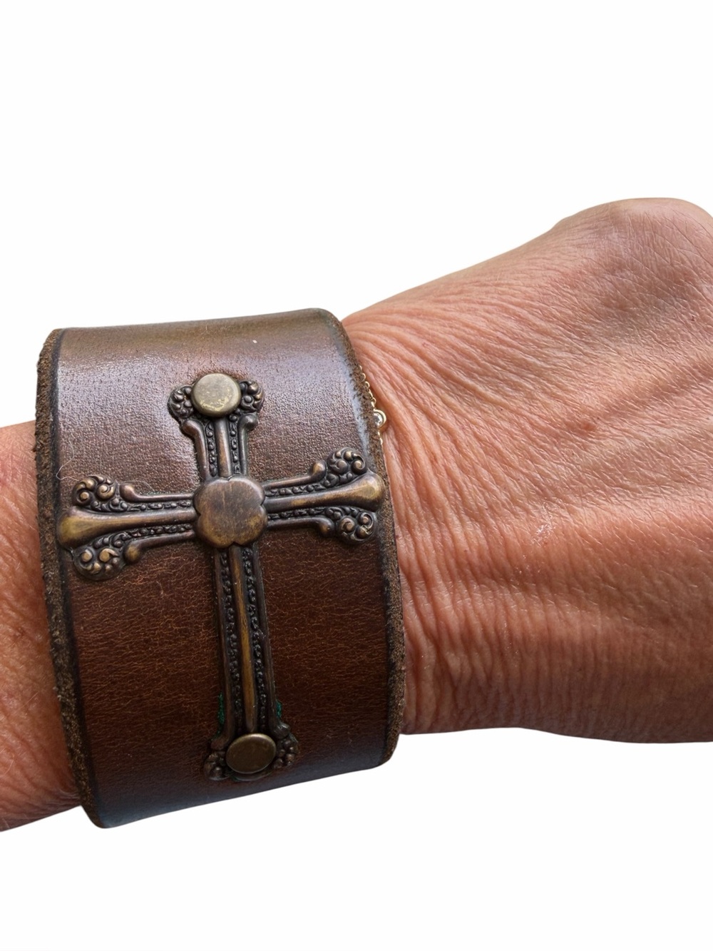 Brown leather cuff bracelet with cross design. Snap closure
